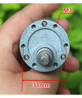 Hand holding a 37MM Geared Electronic Starter, showcasing solid metal gearbox, M3 holes, and 31mm diameter. Kickstart Your Build With This Heavy Duty 37 MM Geared Electronic Starter Boasting A Solid Full Metal Gearbox That Delivers Reliable 1000RPM Power On 6V Or 12V DC For Robot Cars.