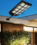 JUDYSSY Solar Street Lights Outdoor Remote Control, 2400W High Brightness Dusk to Dawn Led Lamp mounted on a wall at night.