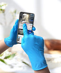 Hands wearing Powder Free Nitrile Disposable Gloves 4 Mil Thick Large 100 Count Latex Free Dark Blue Exam Gloves using smartphone