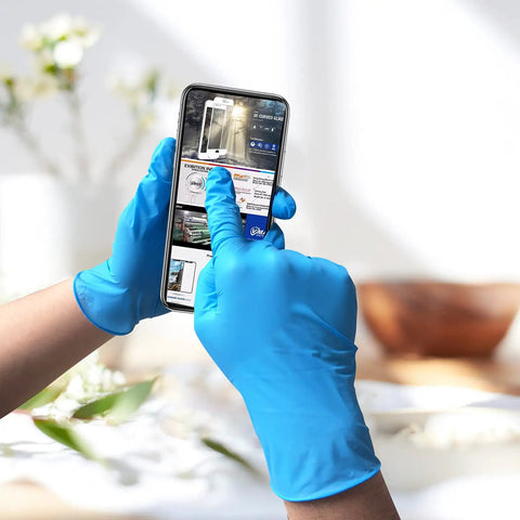 Hands wearing Powder Free Nitrile Disposable Gloves 4 Mil Thick Large 100 Count Latex Free Dark Blue Exam Gloves using smartphone