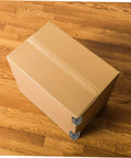 One Hundred Piece Heavy Duty Plastic Corner Protectors L Shaped Edge Guards protecting a cardboard box on a wooden floor.