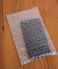 200 Pack 10x15 Cm Double Sided Bubble Padded Mailer Envelopes shockproof waterproof on table with phone inside