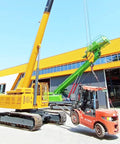 Portable Crawler Crane With 3 Ton Hydraulic Lift And 2 5 Ton Electric Hoist Featuring 360 Degree Spin lifting a forklift outdoors.