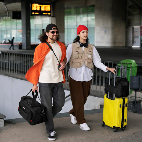 People at airport terminal with Carry On Duffel Bag For Air Travel And Personal Item, softside 16-inch black, and yellow suitcase