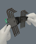 Hands holding TX L Key Set 9 Pc With Ballpoint Torx Long Arm BlackLaser Hardened Blades Hex Plus in clamshell packaging.