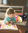 Gooseneck Clip On Desk Lamp With 360 Degree Rotation Easy Clip On Reading Light illuminating a child reading a book.