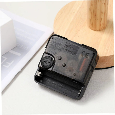 Quartz Clock Movement Replacement Battery Operated DIY Repair Kit For Frameless Craft Clocks And Wall Decor Plug And Play Easy Install Clock Mechanism With 5/32 Inch Thread Length Durable ABS Construction, showing back view on table.