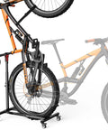 Freestanding Bike Stand With 360 Degree Lockable Wheels, Adjustable Height For Bikes Up To 29 Inches, No Drilling Needed, Holds Up To 80 Lbs, Heavy Duty Bicycle Rack For Garage Or Apartment, Easy Move For MTB And Road Bikes with orange bicycle displayed.