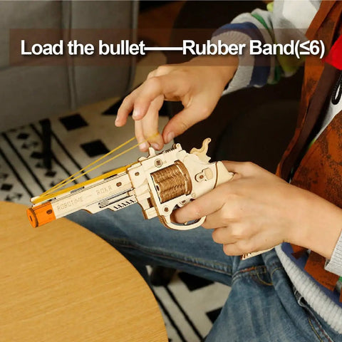 Person loading rubber bands into Dope 3D Wooden Puzzle And Mechanical Model Kit For DIY Builders With Multiplayer Target Shooting Game