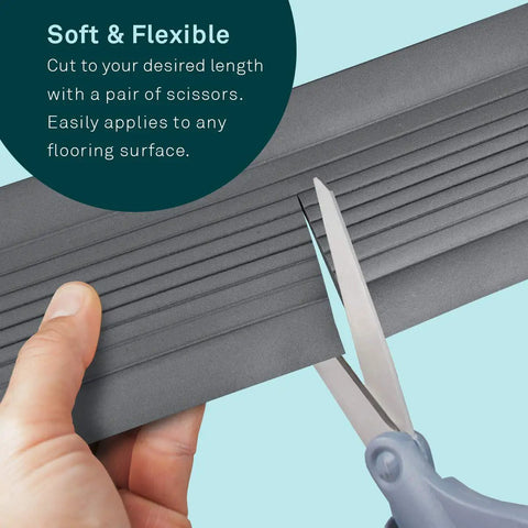 Person cutting 10 Foot Low Profile Cable Blanket Cord Cover And Protector For Floors Gray Ultra Slim with scissors