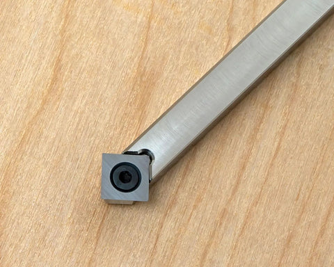 Carbide woodturning tool with square cutter at tip and brushed aluminum shaft.