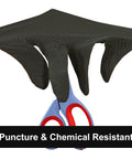 Black nitrile disposable glove with diamond-texture grip worn on hand holding blue scissors