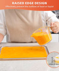 Person pouring liquid onto 4 Pack 14x14 Inch Silicone Dehydrator Trays With Raised Lip Edge Nonstick Sheets For Fruit Leather And Dried Foods Reusable Easy To Clean Dishwasher Safe Great For Fruits Vegetables Herbs Eggs Meat And Liquids on countertop