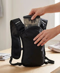 Person placing a water bladder into Hydration Vest Pack With Breathable Nylon Water Bladder Compatible Adjustable Chest Straps Multiple Pockets.
