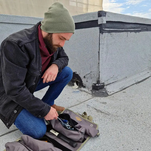 Man using Pro Tool Bag Organizer Foldable Roll Up With Detachable Pouches Wrench Holder And Wrench Roll on rooftop