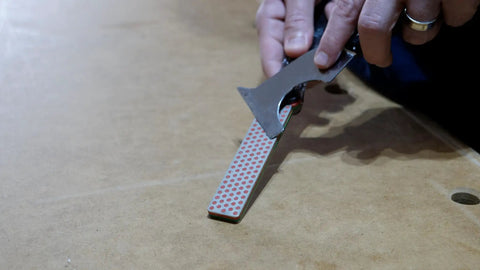 Person using Dia Fold Handy Portable Pocket Diamond Sharpener Double Sided With Extra Fine And Fine Grits on a table.