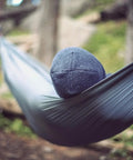 Person relaxing in Go-To Nano 7 Ultra Light Hammock For Camping And Travel With Ripstop Nylon, hung between trees.