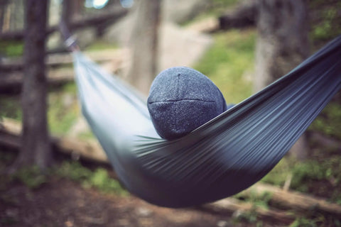 Person relaxing in Go-To Nano 7 Ultra Light Hammock For Camping And Travel With Ripstop Nylon, hung between trees.