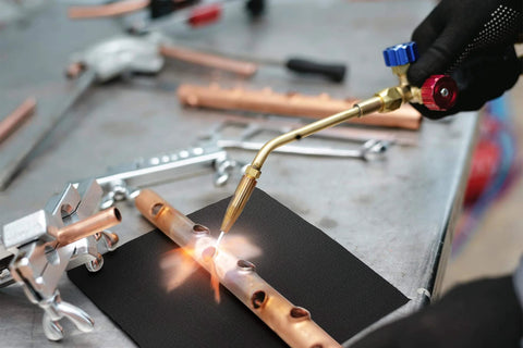 Welder using 9x12 Inch Heavy Duty Heat Shield Barrier Blanket With Reflective Insulation Carbon Felt For High Temp Protection.