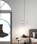 Modern LED Globe Pendant Light With Four Bubble Glass Orbs in bedroom, warm lighting, Gold-Clear design over bedside table