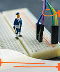 Quick Fix 50 Pack Orange Marker Cable Ties With Blank Labels For Straight Up Wire Grouping on a breadboard with wires.