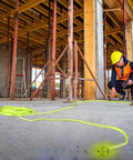Pro Grade 50 Ft Heavy Duty Extension Cord 10/3 AWG SJTW Lighted Plug used on construction site with worker and scaffolding