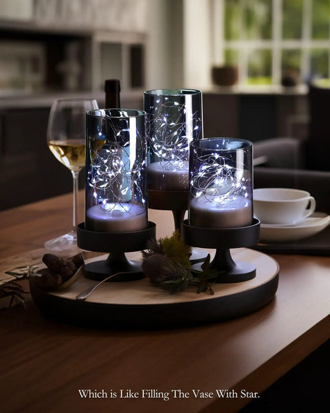 Set Of 3 Flameless Candles In Gray Glass Cylinders With Remote For A Cozy Vibe on a wooden tray with wine glass