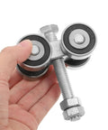 Heavy Duty Dual Bearing Sliding Door Pulley Roller In Tough Matte Black Steel, held in hand, showing dual wheels and mounting bolt.