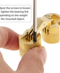 Adjusting screws on an eight piece set of eighteen millimeter concealed brass barrel hinges for cabinet doors.
