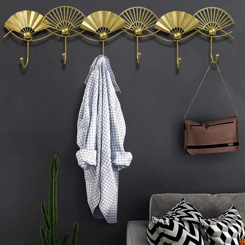 Heavy Duty Artisan Quality Golden Fan Shaped Wall Mount Coat Hook with shirt and bag on hooks in stylish entryway.