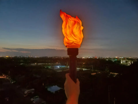 Handheld Realistic Flameless LED Torch Light Prop Lamp For Parties, Holidays, overlooking cityscape at night, flame effect visible.