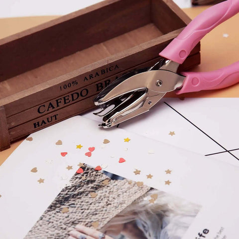 1mm Circle Hole Punch For Craft Paper With Pink Handy Grip Handle next to cut-out craft paper and decorative box
