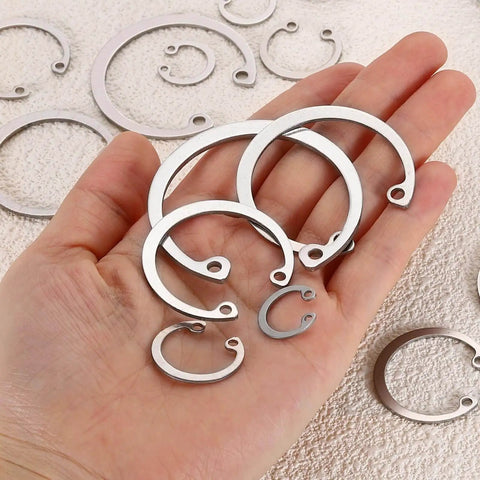 Hand holding various sizes of 12mm Internal Retaining Ring Circlip Kit 100 Pcs 304 Stainless Steel Internal Circlip Snap Rings C Clips GB893