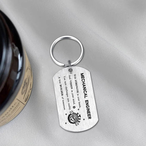 Gearhead Mechanical Engineer Gift Keychain For Students And Pros - Inspirational Engineering Charm For Graduation, Christmas, Or Birthday, stainless steel pendant with engraved text, on soft fabric surface.
