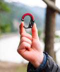 Person holding HeroClip Mini Carabiner Clip And Hook 2 Pack For Travel Luggage Purses And Small Bags Stealth Black 3 In 1 Clip