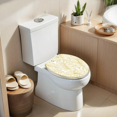 Elongated Vintage luxury seamless floral golden monstera leaves Toilet Seat on a white toilet in a modern bathroom setting.