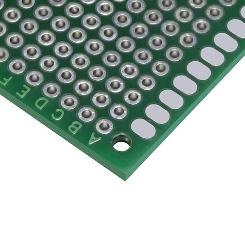 Close-up of a green double-sided PCB from Pack Of 12 Double Sided PCB Prototyping Boards For Diy Soldering Breadboard Projects, 4cm by 6cm Universal Printed Circuit Boards In Red Green And Blue, Perfect For Prototyping And Custom Electronics