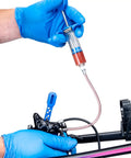 BKM12 Hydraulic Brake Bleed Kit For Mineral Oil with syringe and hose in use on a hydraulic braking system