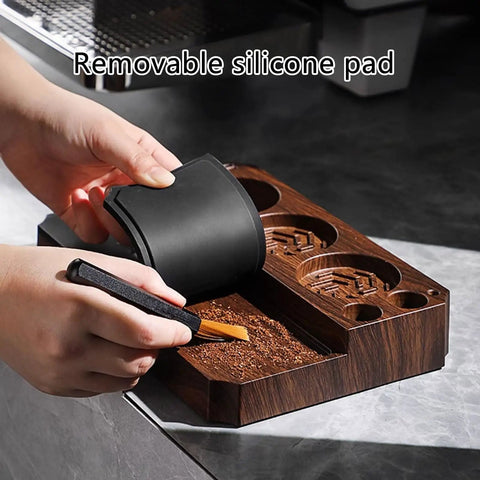 Hand using a brush on coffee grounds with The Legit Non Slip Portafilter Rack And Coffee Distributor Holder Tamper Stand Tool Organizer Tamping Station for Home Barista.