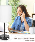 Two Pack Table Lamps With USB Ports And AC Outlet beside a woman on the phone with white fabric shade and black base