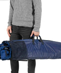 Man holding portable foldable metal framed hammock with cup holder and built-in storage pocket for camping, freestanding, blue