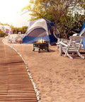 No Mess Smokeless Round Propane Fire Pit For Outdoors with tents and chairs on a sandy beach campground
