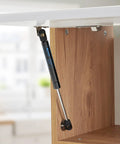 Heavy Duty Gas Struts 10 Inch 18 Lb Lift Supports For Truck Toolbox Cabinet Door installed on cabinet door, black and silver design.