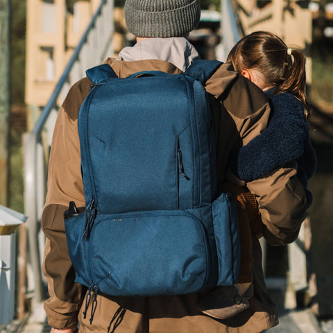 Dad with child wearing Dad Friendly Diaper Bag Backpack With Dual Compartments And Removable Cooler, Rugged And Water Resistant.