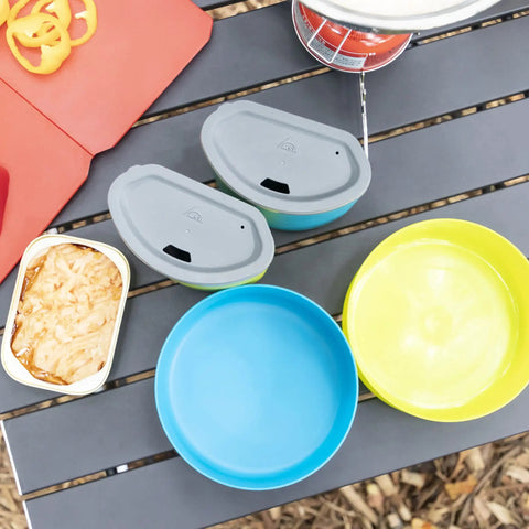 Top view of Two Person Camping Mess Kit with insulated mugs, blue and green deep dish bowls, on a camping table.