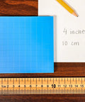 Wooden Meter Stick For Classroom Use With Inches On One Side And Centimeters On The Reverse Hardwood Construction With Clear Lacquer Finish A Kid Friendly Tool For Early Math And Geometry Concepts In Class on table with grid and paper