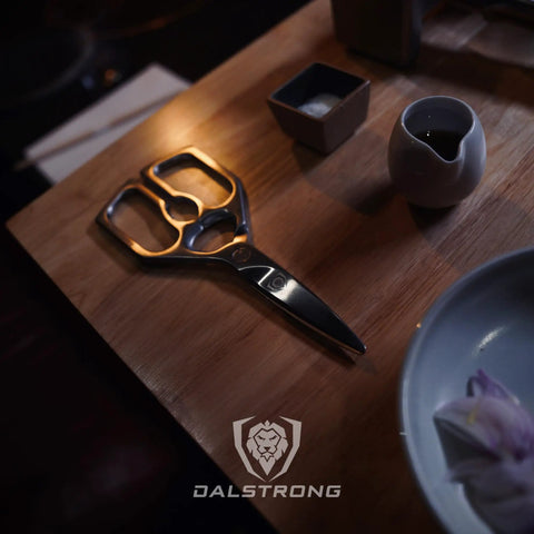 Ambidextrous Japanese Stainless Steel Kitchen Scissors For Spatchcocking Chicken, Trimming Fat, And Breaking Down Poultry, Also Great For Pizza, Flatbread, Herbs, Quesadillas, And Quick Package Opening, Detachable For Easy Cleaning. Black stainless kitchen scissors on wooden table