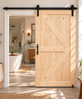 Unfinished 42 Inch by 84 Inch British Brace Knotty Barn Door with Double Sided Finish Made of Solid Canadian Spruce Includes Sliding Hardware Kit installed in a modern home interior.