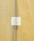 Clear Self Adhesive Folding Hinge Set, Acrylic 20 Pack on wooden surface, showing transparent and flexible design for cabinets