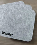 Snag This 4 Pack Of Polyester Fiber Acoustic Panels Self Adhesive Sound Proof Tiles 0.4 Inch Thick Provide Superior Noise Absorption To Banish Echo And Reverberation Boosting Audio Clarity Plus Textured Decor That Keeps Your Vibe Chill And Professional - Four gray polyester acoustic tiles with rounded corners on a wooden surface.
